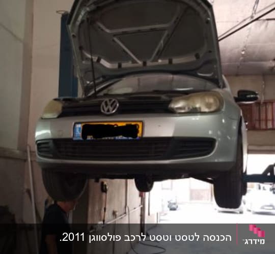רכב מורם במוסך עם מכסה מנוע פתוח